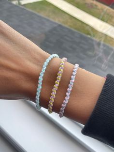 a woman's arm with three bracelets on it, both wearing different colors