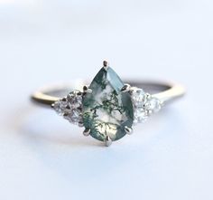 Best seller at Capucinne - A delicate marquise engagement ring features teal sapphire with side diamonds. A beautiful genuine teal - green sapphire complimented with diamonds to create a simple yet stunning ring. Please click for larger Moss Agate Engagement Ring White Gold, Unique Pear Engagement Ring, Pear Moss, Forest Weddings, Agate Wedding Ring, Green Quince, Az Wedding, Moss Agate Jewelry, Witch Room