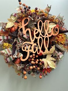 a wreath with the word hello fall written in cursive font surrounded by autumn leaves and berries