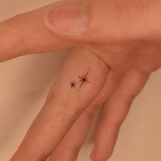 a person's hand with a tiny star tattoo on it