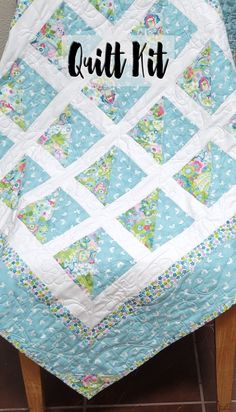 a quilt kit sitting on top of a wooden table next to a chair with the words,