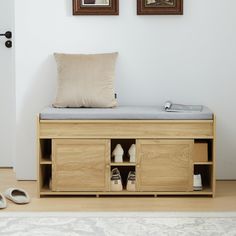 a wooden bench with shoes on it in front of two framed pictures