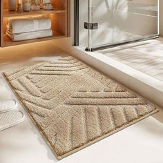 a bathroom area with a rug, shower door and towels