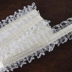 two white lace garters laying on top of a wooden table next to each other