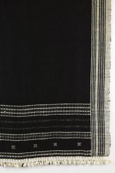 a black and white striped rug with tassels on the edges, in front of a white background