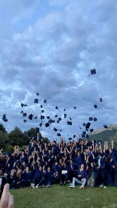 a group of graduates throwing their caps in the air while they are on graduation day