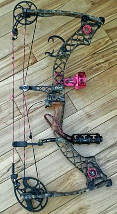 a bow that is laying on the floor next to some other bows and arrows in front of it