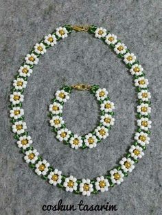 a necklace and bracelet made out of beads with flowers on the bottom, sitting on a gray surface