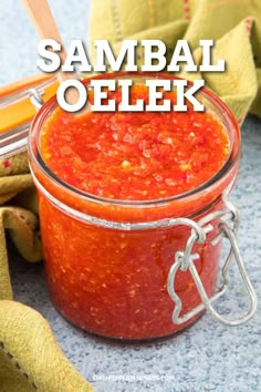 a glass jar filled with salsa sitting on top of a table next to other items