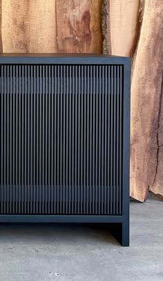 a black cabinet sitting on top of a cement floor