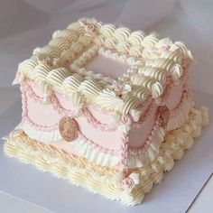 a pink and white cake that is on a table