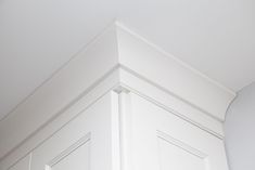 the corner of a kitchen cabinet with white paint