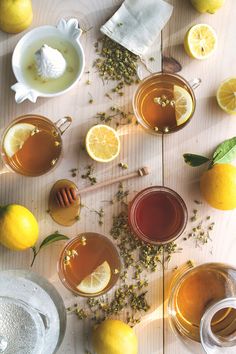 there are many different types of teas on the table with lemons and honey