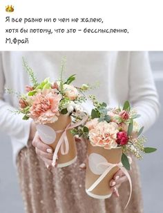 two women holding vases with flowers and hearts painted on the side, one is holding a bouquet