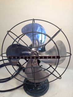 an old fashioned metal fan sitting on top of a table