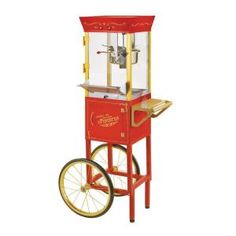 an old fashioned popcorn vending machine with wheels on the front and sides, in red