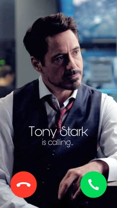 tony stark is calling on the phone and he's wearing a vest with a red tie