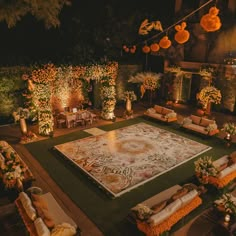 an outdoor wedding venue decorated in orange and white flowers, with lots of greenery