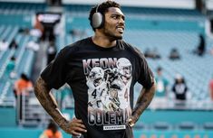 a man wearing headphones standing in front of a stadium