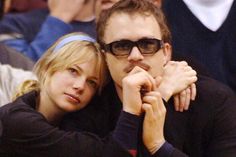 a man and woman sitting next to each other at a basketball game