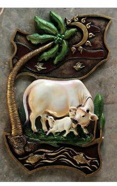 a cow and calf are depicted in this decorative plaque