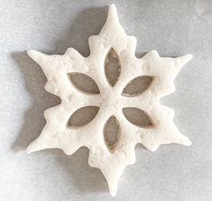 a snowflake shaped object sitting on top of a white tablecloth covered floor