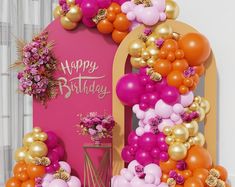 a birthday party with balloons and flowers on the front door, decorated in gold, pink, and orange colors