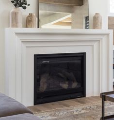 a living room with a fire place and a mirror on the wall above it's mantle