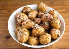 a white bowl filled with fried food on top of a wooden table