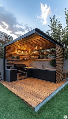 an outdoor kitchen is built into the side of a wooden deck with grill and barbecue area