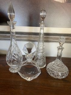 three glass decanters on a wooden table