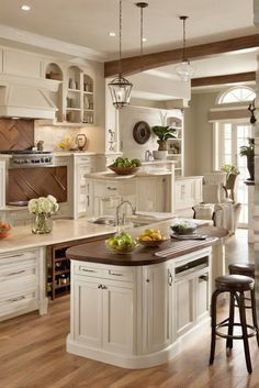 a large kitchen with white cabinets and wooden floors