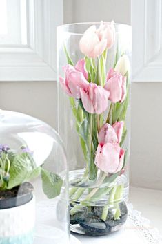 some pink flowers in a glass vase on a table