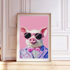 a pig wearing sunglasses and a pink bow tie in front of a framed photograph on the wall