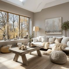 a living room filled with lots of furniture next to large windows and a wooden table