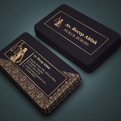 two black and gold business cards on a dark background