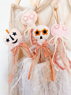 three cloth dolls sitting on top of a white net