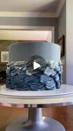 a cake with blue icing and white frosting is on top of a table