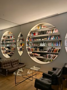 three circular windows in the middle of a room filled with furniture and bookshelves