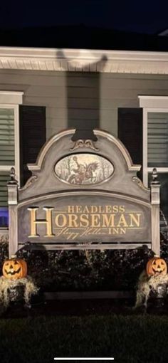 a sign that says headless horseman in front of a house with pumpkins