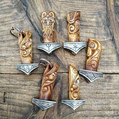 four different types of knife blades on top of a wooden table next to each other