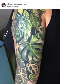 a woman's arm with green leaves on it