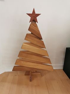 a small wooden christmas tree sitting on top of a hard wood floor