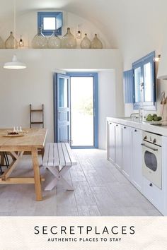 a kitchen with a table and chairs in front of an open door that leads to the outside