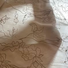 an image of a table cloth with flowers and leaves drawn on it in black ink