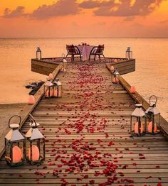 a pier with lanterns and rose petals on it