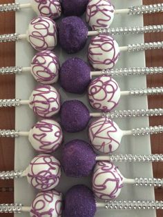 purple and white cake pops are arranged on a plate