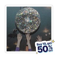 two people reaching up to grab a disco ball