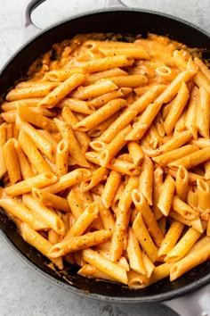 a skillet filled with pasta on top of a table