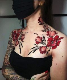 a woman with tattoos on her chest wearing a black face mask and covering her eyes